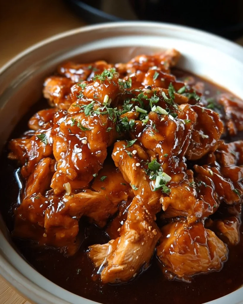 Delicious crockpot honey garlic chicken garnished with fresh herbs