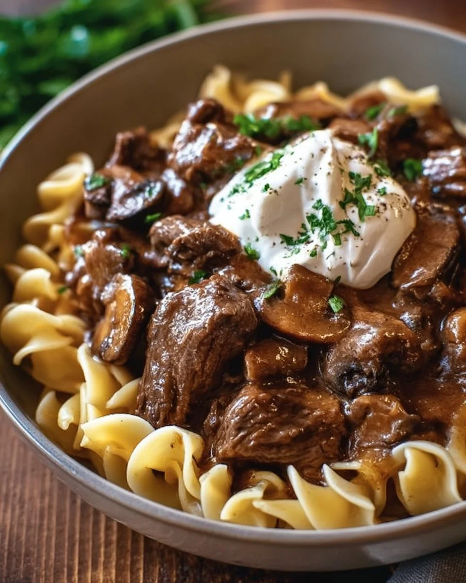 Slow Cooker Pot Roast Beef Stroganoff served with noodles and garnished with parsley.