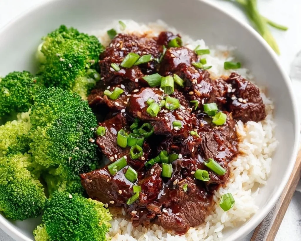 Slow Cooker Korean Beef dish garnished with green onions and sesame seeds.
