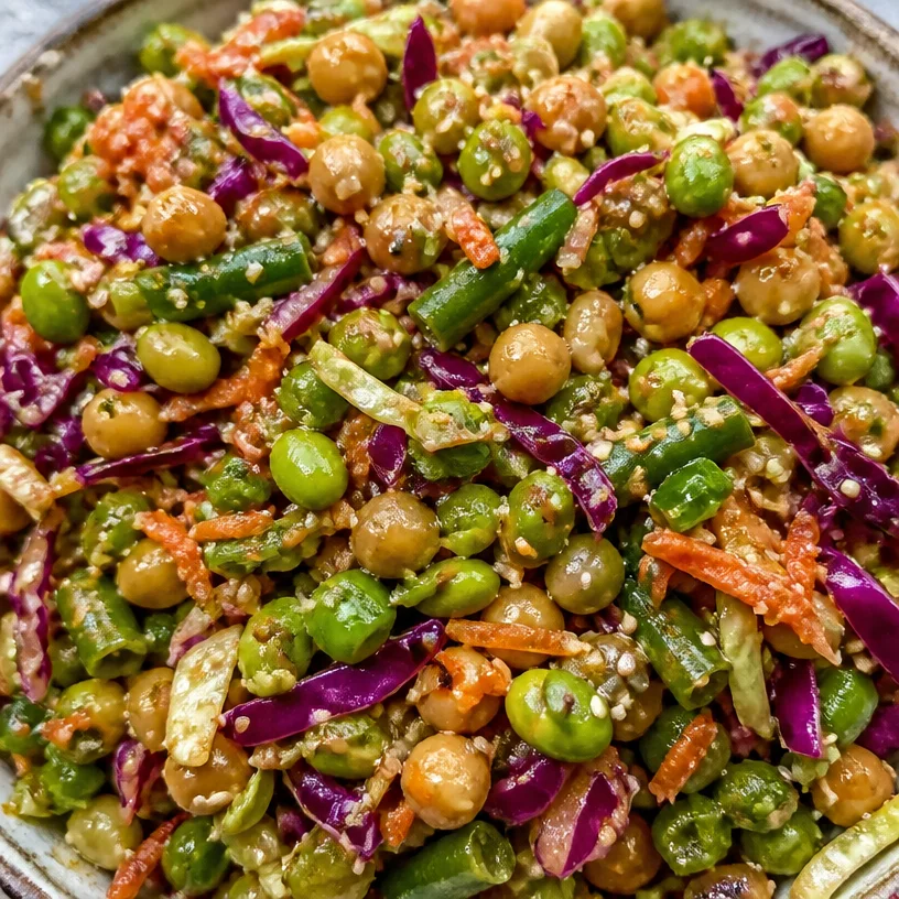 Miso sesame dense bean salad with vibrant vegetables and garnishes.